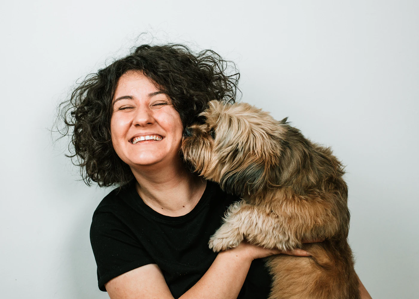 Köpeğine sarılan gülümseyen kadın